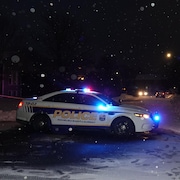 Une voiture de police sous la neige.