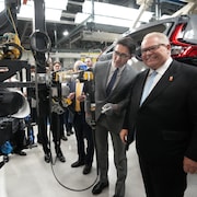 Le premier ministre canadien, Justin Trudeau, et son homologue ontarien, Doug Ford, observent la technologie de Honda dans une usine. 
