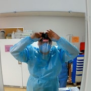 Le Dr Patrick Bellemare se regarde dans le miroir afin de s'assurer que sa caméra enregistre.