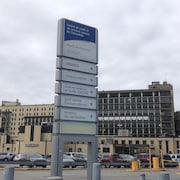 Un stationnement d'hôpital avec une grosse affiche.