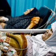 Des patients sont étendus sur des civières. 