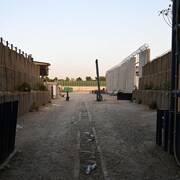 Un chemin de terre battue et un point de contrôle devant l'ambassade du Canada à Kaboul.