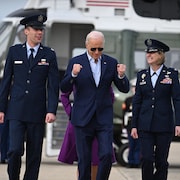 Joe Biden sur un tarmac entouré de deux pilotes.