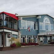 La façade de l'Hostellerie Baie Bleue et du Pub Saint-Joseph, qui comporte une terrasse au deuxième étage.