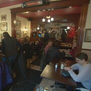 La salle à manger d'un restaurant remplie de clients attablés.