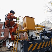 Un homme monte dans la nacelle d'un camion d'Hydro-Québec.