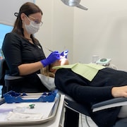 Une hygiéniste dentaire soigne une patiente.