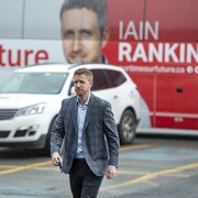 Iain Rankin marche en sortant de son autobus de campagne électorale, le 30 juillet 2021, à Halifax.