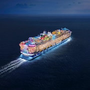 Le Icon of the Seas illuminé naviguant sur l'eau.