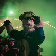 Un festivalier en costume de yéti danse à l'extérieur. 