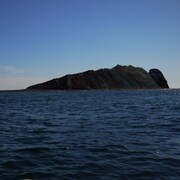 Un îlot rocheux en forme de personne étendue.