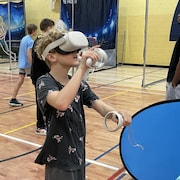Un élève joue à un jeu avec des lunettes de réalité virtuelle.