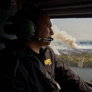 Le premier ministre du Manitoba, Wab Kinew, surveille les feux de forêt qui brûlent dans le nord de la province depuis un hélicoptère, mardi.
