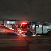 Un camion de pompier devant l'immeuble incendié.