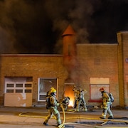 Des pompiers combattent des flammes.