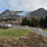 De la fumée qui s'échappe d'un feu de forêt sur une montagne.