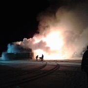 Un feu ravage un bâtiment dans la nuit. 