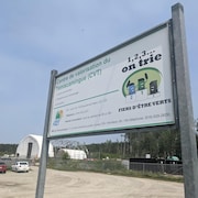 Un incinérateur à l'arrière-plan avec l'enseigne d'accueil devant.
