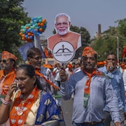 Des partisans du premier ministre indien Narendra Modi défilent dans les rues avec des affiches à son effigie.