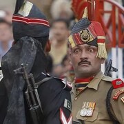 Un militaire indien (de face) toise un militaire pakistanais (de dos). 
