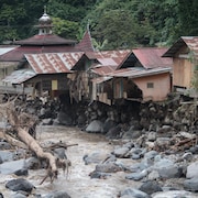Des maisons situées près d'une rivière sont endommagées.