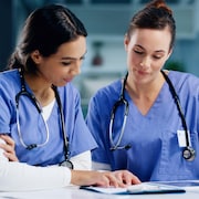 Deux infirmières discutent à l'hôpital. 