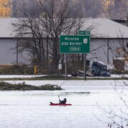 Deux personnes en kayak sur une autoroute inondée.