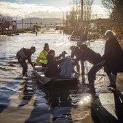 Des gens dans une barque lors d'inondations en Colombie-Britannique.