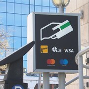 Une affiche d'une caisse Desjardins au centre-ville de Trois-Rivières qui a le logo d'Interac, de Visa et Mastercard et qui indique la présence d'un guichet automatique.