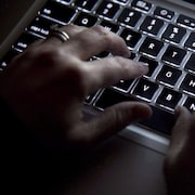 Les mains d'un adulte sur un clavier.