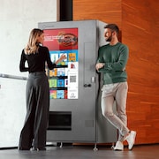 Une femme achète une boisson dans un distributeur automatique d'Invenda.