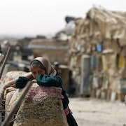 Une jeune fille irakienne se tient devant la hutte familiale construite près d'un dépotoir dans la périphérie de Bagdad.