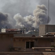 De la fumée s'élève dans le ciel, alors que les combats pour reprendre la ville de Mossoul aux mains des djihadistes du groupe armé État islamique se poursuivent.