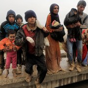 Des familles irakiennes qui ont fui la ville de Mossoul s'apprêtent à monter dans un camion.