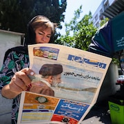 Une femme lit un journal qui annonce la mort du président.
