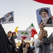 Des personnes brandissent des photos et des drapeaux iraniens.