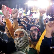 Des hommes l&egrave;vent le poing.