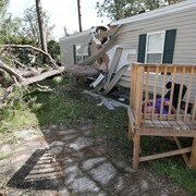 Un homme est étendu près de sa maison détruite par la chute d'un arbre après le passage de l'ouragan Irma, à Kissimmee en Floride.