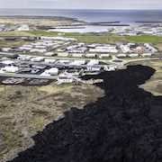 De la lave refroidie entre dans un village en Islande, au cours d'une éruption volcanique. 