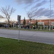 Des dizaines de personnes attendent à l’extérieur. 