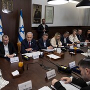 Des hommes et des femmes en réunion autour d'une table.