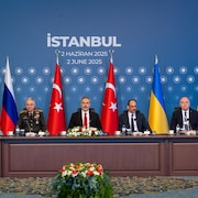 Des membres des délégations ukrainienne et russe assistent à des pourparlers de paix présidés par le ministre turc des Affaires étrangères, Hakan Fidan (au centre), en Turquie.