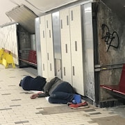 Deux itinérants dorment dans le métro, à la station Beaudry.