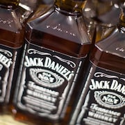Trois bouteilles de Jack Daniels sur une tablette.