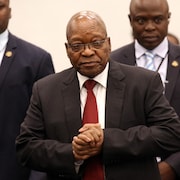 Jacob Zuma marche escorté par deux hommes.  