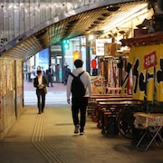 Deux hommes se croisent sans se regarder le soir à Tokyo.