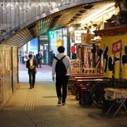 Deux hommes se croisent sans se regarder le soir à Tokyo.