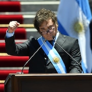 Javier Milei lève le poing lors d'un discours.