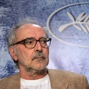 Jean-Luc Godard regarde quelqu'un dans la salle, lors d'une conférence de presse à Cannes, en 2004.