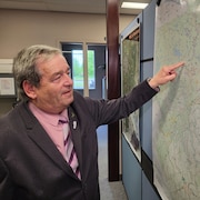 Jean-Yves St-Arnaud qui pointe un endroit sur une carte.